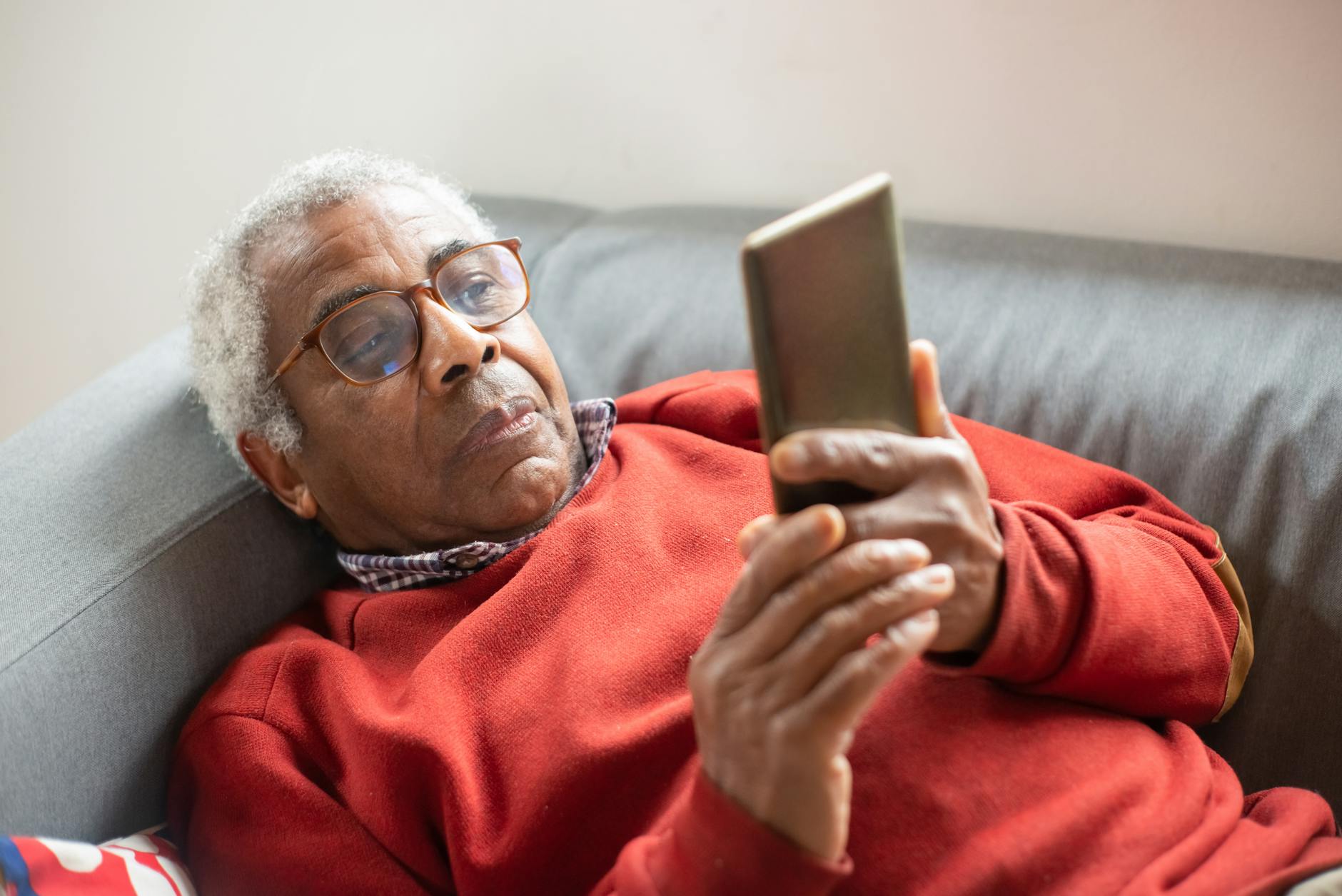 an elderly man with eyeglasses using his cell phone